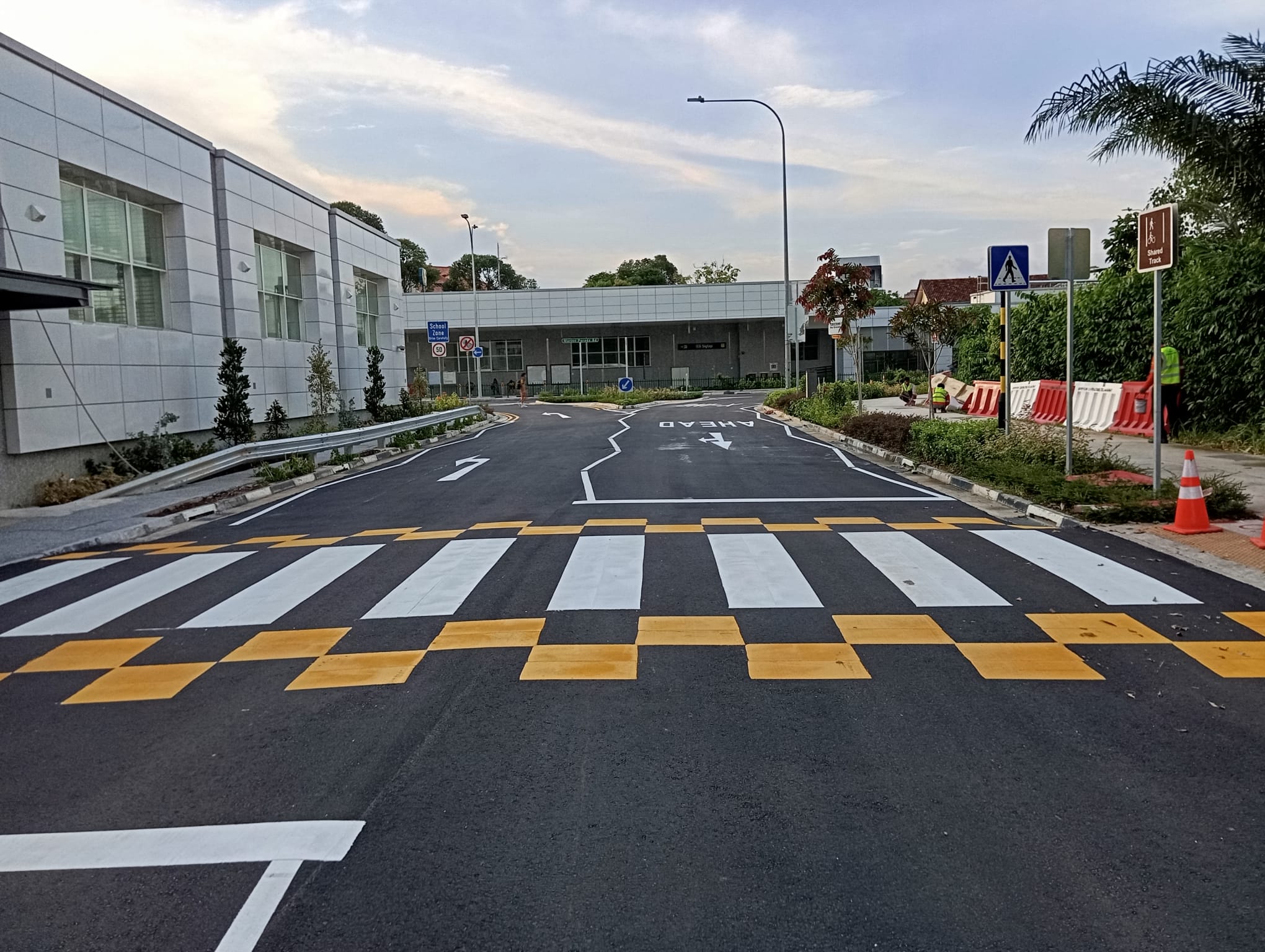 Completed school zone road marking with checkered crossing and directional arrows by EMK Construction